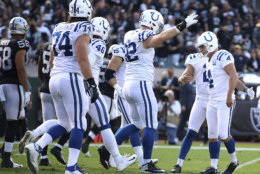 Indianapolis Colts kicker Adam Vinatieri, right, is congratulated by teammates after kicking a field goal against the Oakland Raiders during the first half of an NFL football game in Oakland, Calif., Sunday, Oct. 28, 2018. Vinatieri surpassed Morten Andersen's NFL record for points with this kick. (AP Photo/Ben Margot)