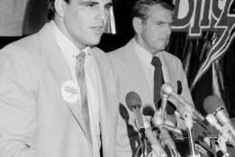 Tim Wrightman, left, former UCLA tight end and a third round draft choice of the Chicago Bears, announces at a press conference in Chicago, Ill., that he has signed a two-year contract with the Chicago Blitz of the newly-formed USFL, Aug. 6, 1982. George Allen, right, said the signing was a "historic day, he's the first major player signed by the league, the first with total credibility." Allen will be the coach of the Blitz. (AP Photo/Charles Knoblock)