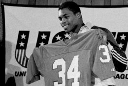 Former Georgia football player Herschel Walker holds up his new jersey at a press conference in Orlando, Fla., Feb. 26, 1983. Walker joined the New Jersey Generals of the USFL and worked out for the first time at their spring camp at the University of Central Florida. (AP Photo/Ron Lindsey)