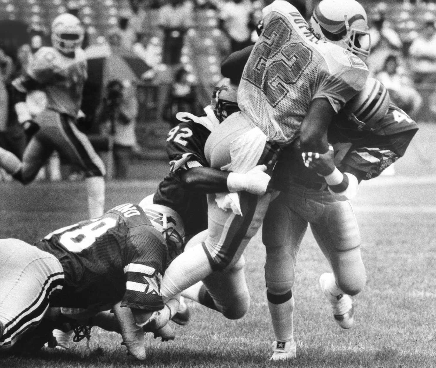 Running back Marcus Dupree (22) of the New Orleans Breakers, gets caught in a crowd of Washington Federals defenders during the first half of game on Sunday, June 24, 1984 at Robert F. Kennedy Stadium in Washington. The Federals topped the contest 20-17. (AP Photo/Richard Folkers)