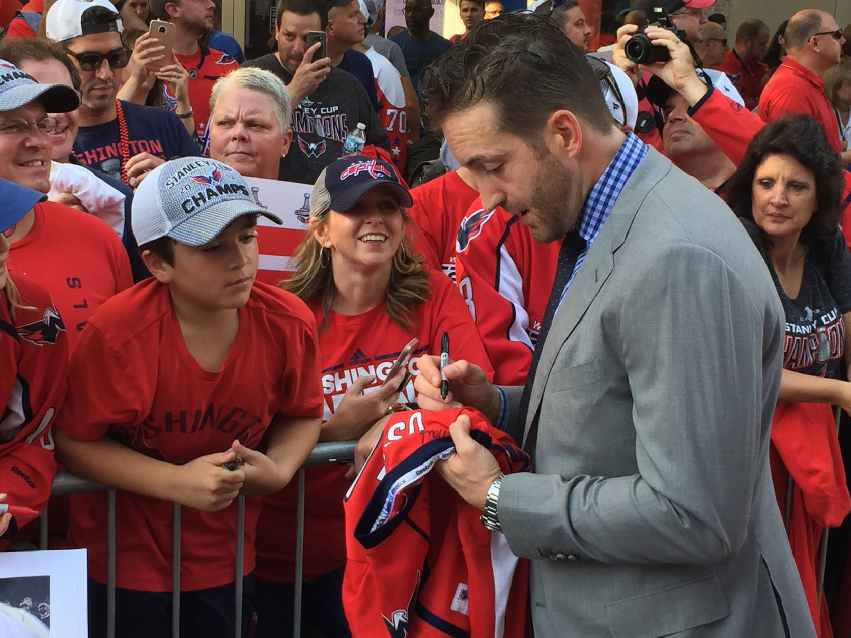 The Capitals' Brooks Orpik signs a jersey as the Caps arrive at the 2018-2019 season opener. (WTOP/Jonathan Warner)
