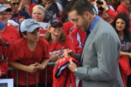 The Capitals' Brooks Orpik signs a jersey as the Caps arrive at the 2018-2019 season opener. (WTOP/Jonathan Warner)