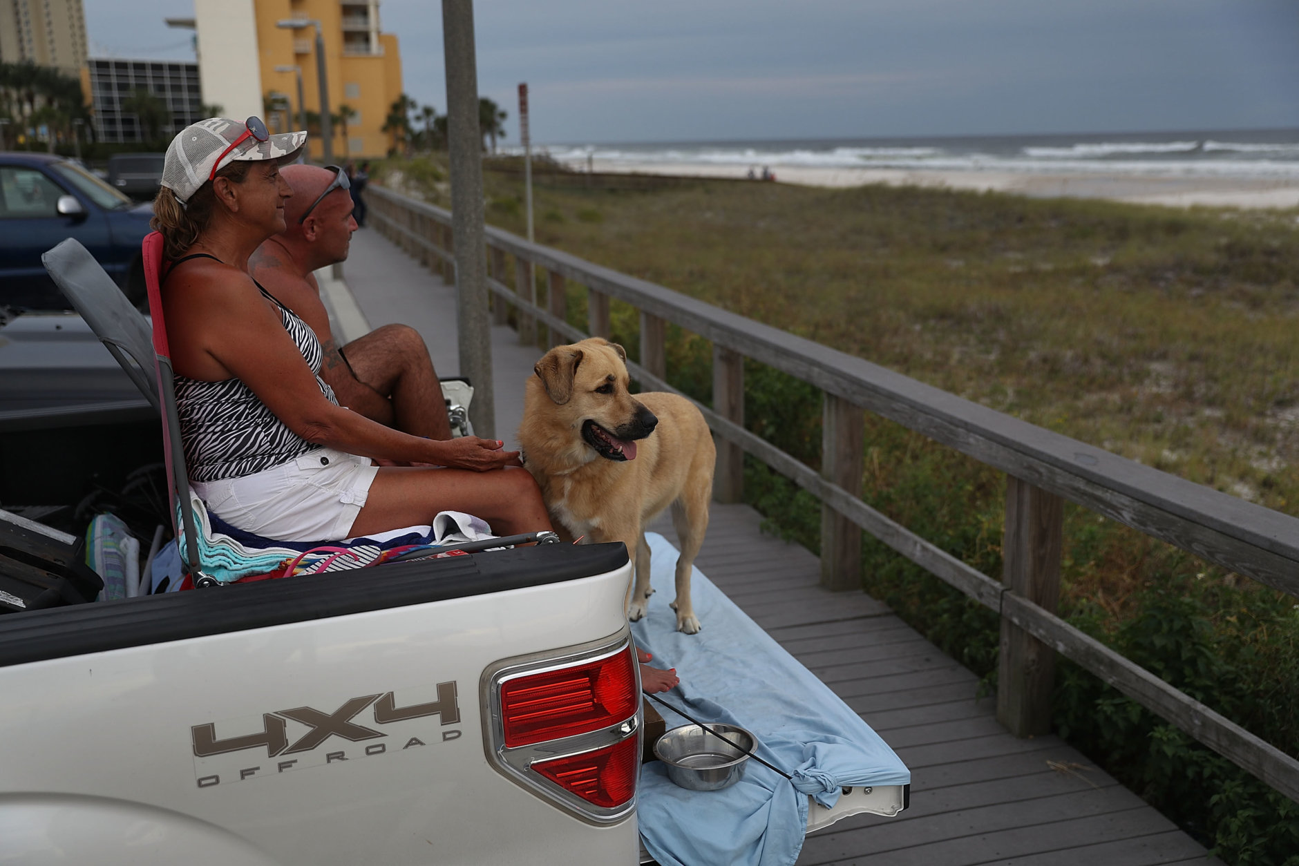 PANAMA CITY, FL - OCTOBER 09:  David Gage and Christal Gage and their dog, Bear, relax on the back of their pickup truck next to the ocean as they wait for the arrival of Hurricane Michael on October 9, 2018 in Parker, Florida. Michael, which strengthened to a Category 3 storm today with sustained winds of 120 mph, is expected to make landfall in the Florida Panhandle by Wednesday.   (Photo by Joe Raedle/Getty Images)