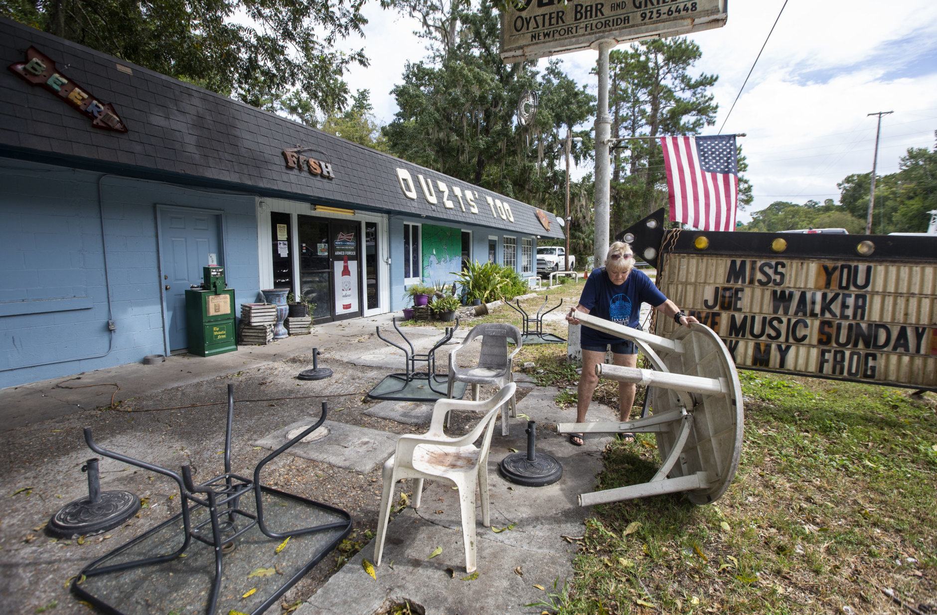 NEWPORT, FL - OCTOBER 09: Bar owner Dorothy White puts away outdoor furniture at Ouzts Too bar prior to the arrival of Hurricane Michael on October 9, 2018 in Newport, Florida. (Photo by Mark Wallheiser/Getty Images)