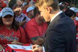 The Capitals' Jacob Vrana signs an autograph as the Caps arrive at the 2018-2019 season opener. (WTOP/Jonathan Warner)