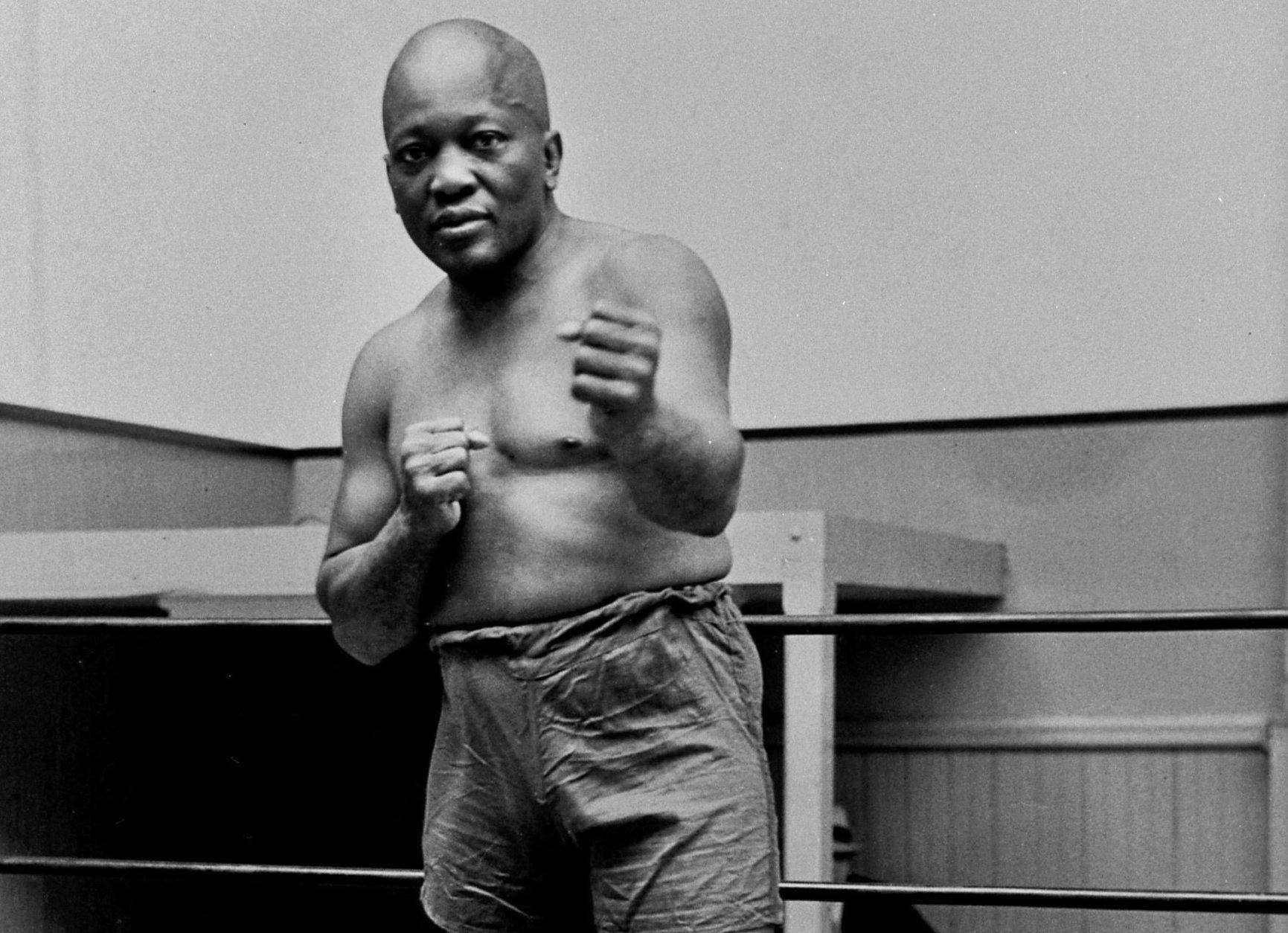 FILE - In this 1932 file photo, boxer Jack Johnson, the first black world heavyweight champion, poses in New York City.  A Texas Gulf Coast home where Johnson once lived has been heavily damaged in a fire.
The blaze caused a wall to collapse in the vacant home Friday, April 5, 2019 in Galveston, Texas. Fire Chief Mike Wisko said that the building was in the process of being renovated. (AP Photo/File)