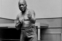 FILE - In this 1932 file photo, boxer Jack Johnson, the first black world heavyweight champion, poses in New York City.  A Texas Gulf Coast home where Johnson once lived has been heavily damaged in a fire.
The blaze caused a wall to collapse in the vacant home Friday, April 5, 2019 in Galveston, Texas. Fire Chief Mike Wisko said that the building was in the process of being renovated. (AP Photo/File)