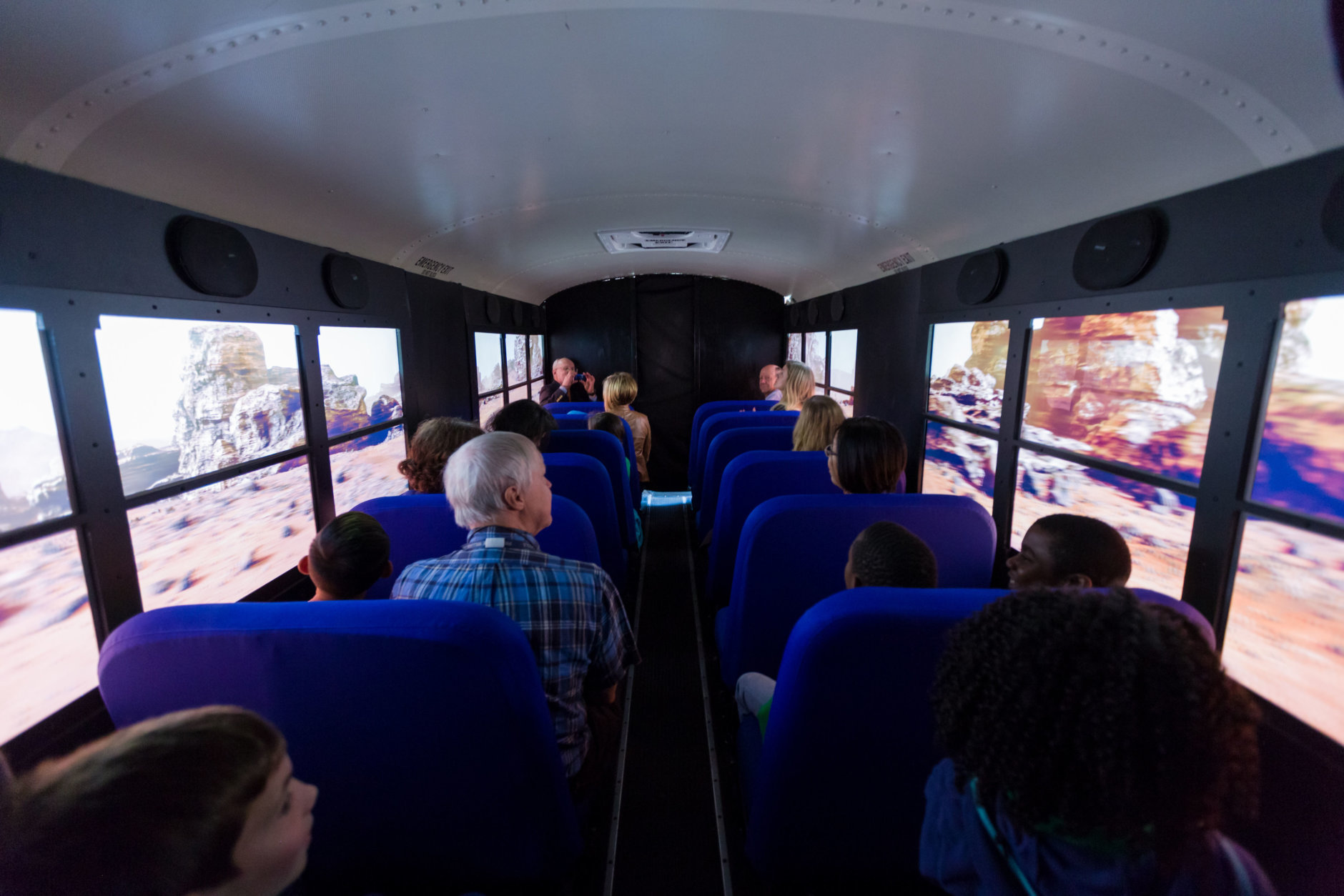 Students and chaperones from Virginia's Loch Lomond Elementary School robotics team watch as they seem to travel across the surface of the planet Mars, seated in the Lockheed Martin Mars Experience bus at the the Steven F. Udvar-Hazy Center, in Chantilly, Oct. 19, 2018. The bus, fitted with high-definition monitors on the windows, provides visitors an opportunity to experience the Martian surface. (Air and Space photo by Daniel Soñé)