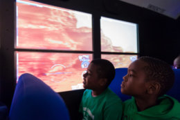 Amos Kear, 9, left, and Nate Wilson, 8, look at the surface of the planet Mars, seated in the Lockheed Martin Mars Experience bus. The boys and their classmates from Virginia's Loch Lomond Elementary School robotics team were the first group of local students to visit the bus at the the Steven F. Udvar-Hazy Center in Chantilly, Virginia, Oct. 19, 2018, following a ceremony in which Lockheed Martin transferred the bus to Smithsonian's Air &amp; Space Museum. The bus, fitted with high-definition monitors on the windows, provides visitors an opportunity to experience the Martian surface. (Air and Space photo by Daniel Soñé)