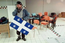 Quebec secession campaign volunteer Remi Gagne holds the Quebec flag during clean up at the group's campaign office in Montreal, Canada, Tuesday, Oct. 31, 1995, a day after voters narrowly turned down the province's independence referendum. (AP Photo/Eric Draper)