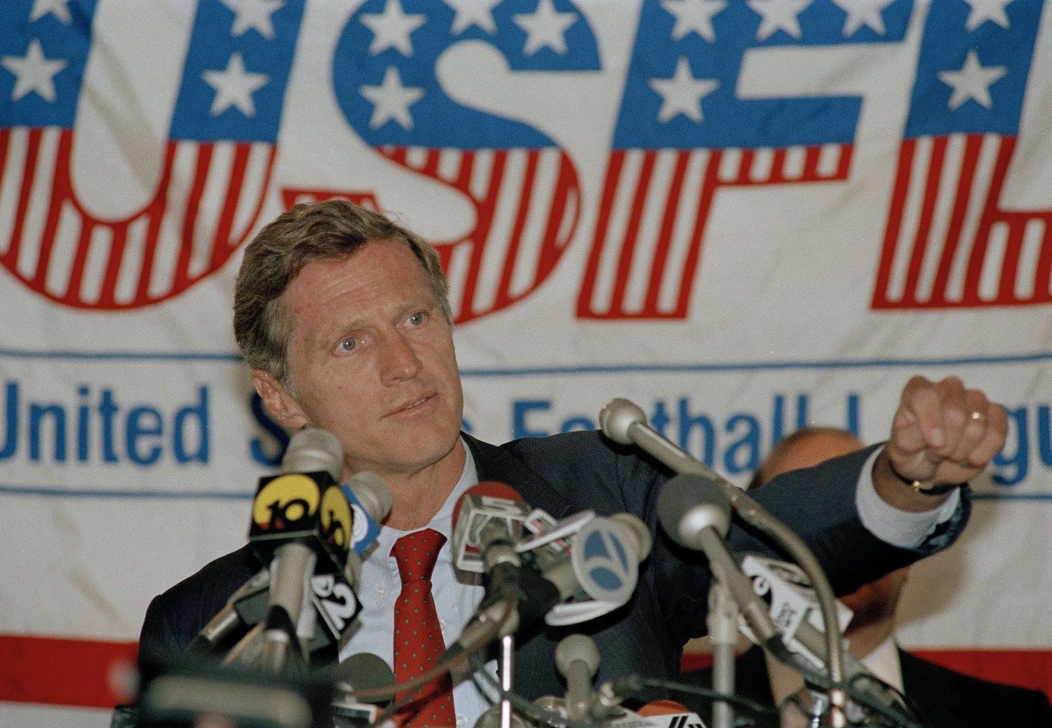 United States Football League commissioner Harry Usher gestures during a news conference in New York, Aug. 4, 1986. the USFL club owners voted to suspend play until 1987, less than a week after they were awarded only $3 in damages in a $1.69 billion anti-trust suit against the National Football League. The eight-team league, which operated for three years with a spring-summer schedule, was to have opened its first fall schedule on Sept. 13. (AP Photo/Susan Ragan)