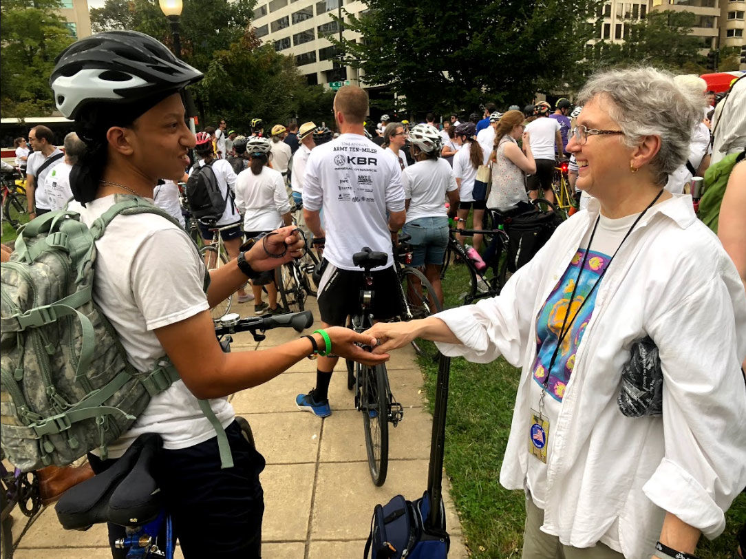 A large group of cyclists, mostly dressed in white, gathered at D.C.'s Farragut Square on Thursday to honor fallen fellow rider Thomas Hollowell. (WTOP/Mike Murillo)