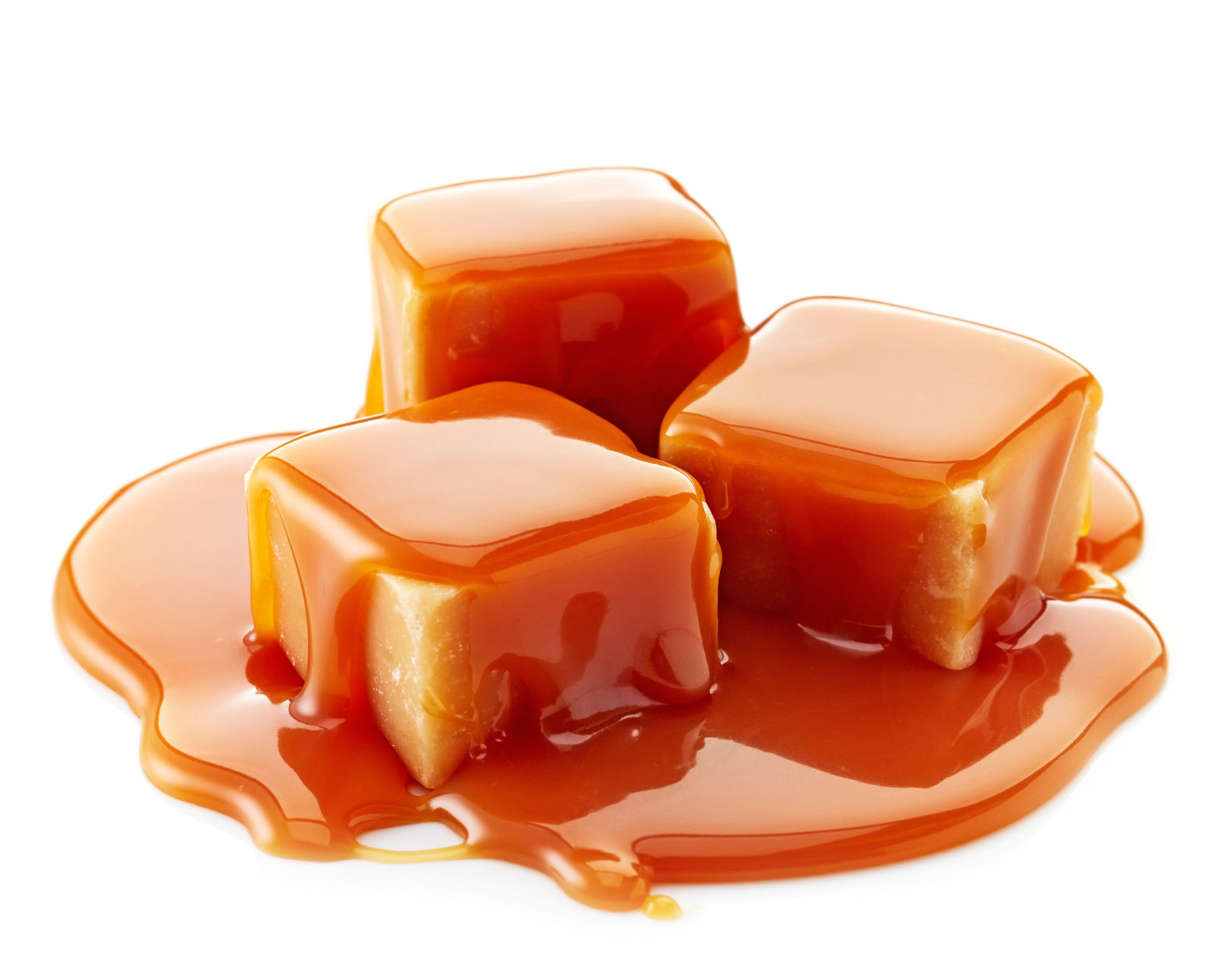 caramel candies and caramel sauce on a white background