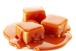 caramel candies and caramel sauce on a white background