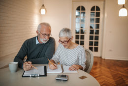 A senior couple taking a closer look at their budget in the comfort of their home.