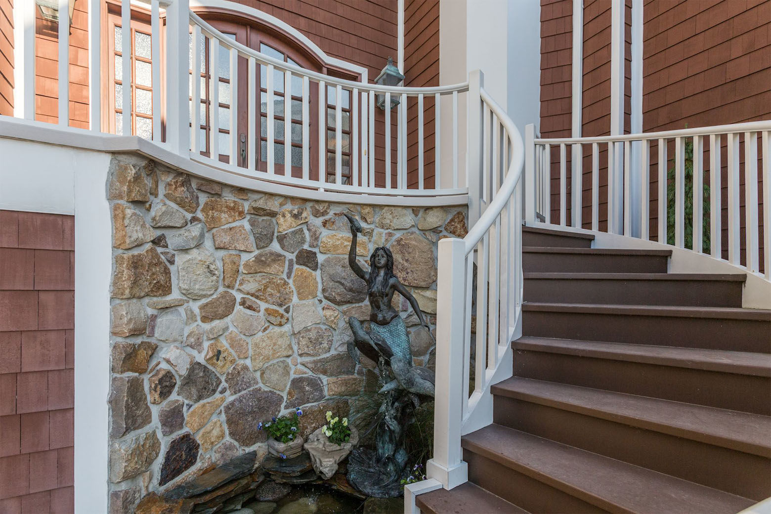 The curved staircase to the home's front entrance. (Courtesy HomeVisit)