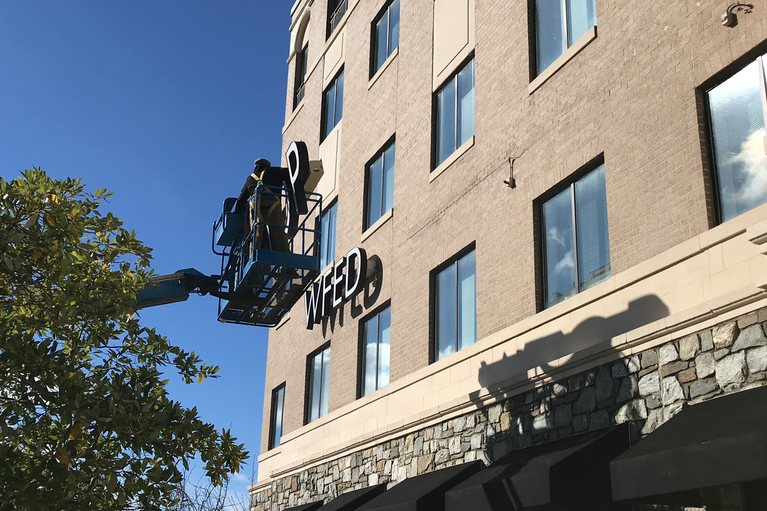 Crews removing WTOP's call letters from its Idaho Avenue location. (WTOP/Ginger Whitaker)