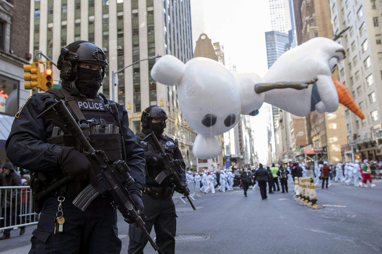 Heavily-armed police officers stand guard as the Olaf balloon floats down 6th Avenue during the 92nd annual Macy's Thanksgiving Day Parade, Thursday, Nov. 22, 2018, in New York. (AP Photo/Mary Altaffer)