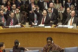 Left to right, Syria's deputy U.N. Ambassador Fayssal Mekdad, Britain's Ambassador Jeremy Greenstock and U.S. Amabassador John Negroponte vote on an Iraq resolution in the U.N. Security Council chambers Friday, Nov. 8, 2002.  The Security Council unanimously approved a tough new Iraq resolution Friday, aimed at forcing Saddam Hussein to disarm or face "serious consequences'' that would almost certainly mean war. (AP Photo/Bebeto Matthews)