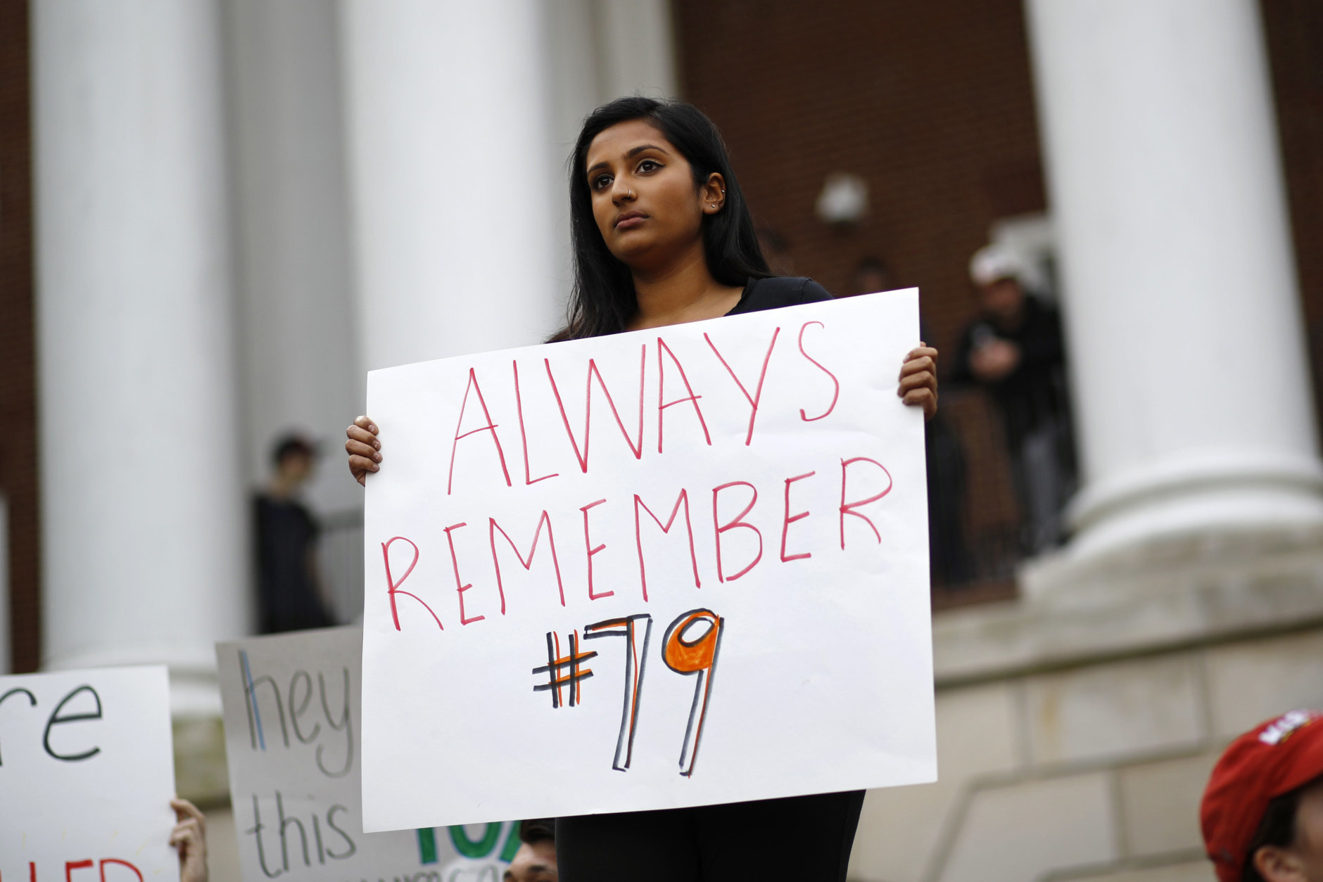 University of Maryland student Ro Nambiar holds a sign as people gather at a "Justice for Jordan" rally in remembrance of offensive lineman Jordan McNair, Thursday, Nov. 1, 2018, on the university's campus in College Park, Md. Maryland President Wallace Loh fired football head coach DJ Durkin Wednesday, about five months after McNair collapsed on a practice field and later died of heatstroke. (AP Photo/Patrick Semansky)