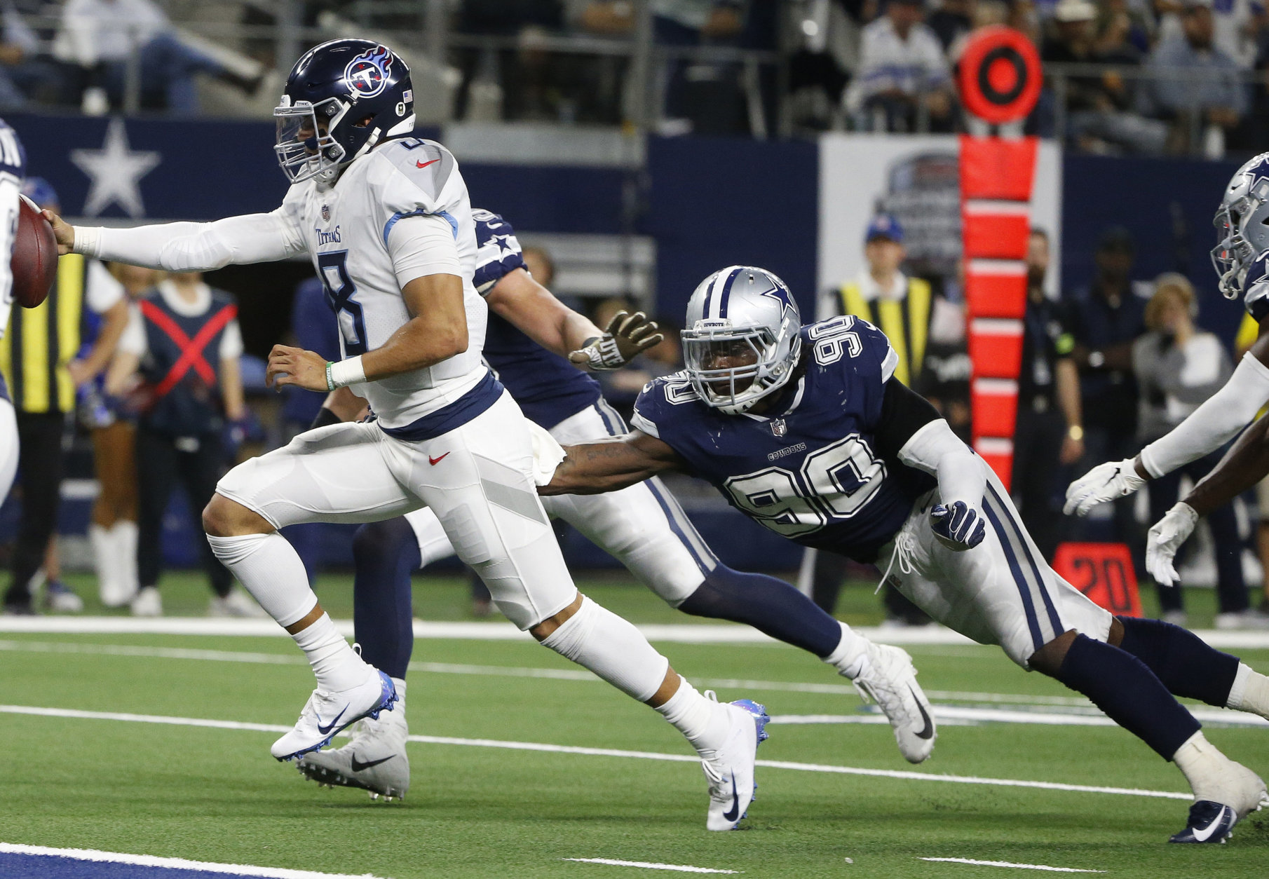 Tennessee Titans quarterback Marcus Mariota (8) runs for a touchdown against Dallas Cowboys defensive end Demarcus Lawrence (90) during the second half of an NFL football game, Monday, Nov. 5, 2018, in Arlington, Texas. (AP Photo/Michael Ainsworth)
