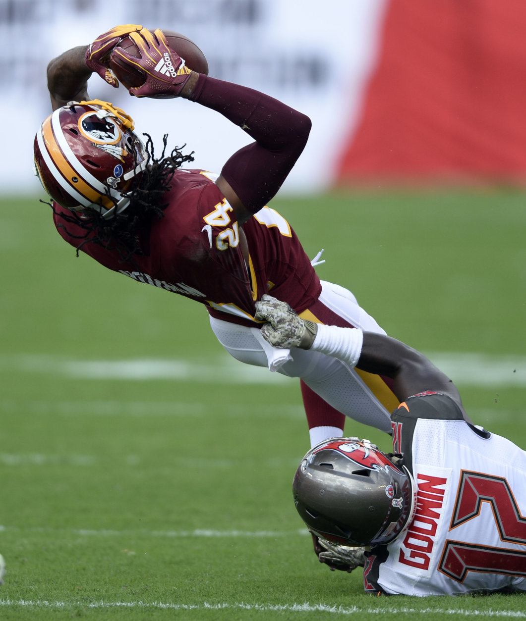 Washington Redskins cornerback Josh Norman (24) interecpts a pass by Tampa Bay Buccaneers' Ryan Fitzpatrick (14) intended for wide receiver Chris Godwin (12) during the first half of an NFL football game Sunday, Nov. 11, 2018, in Tampa, Fla. (AP Photo/Jason Behnken)