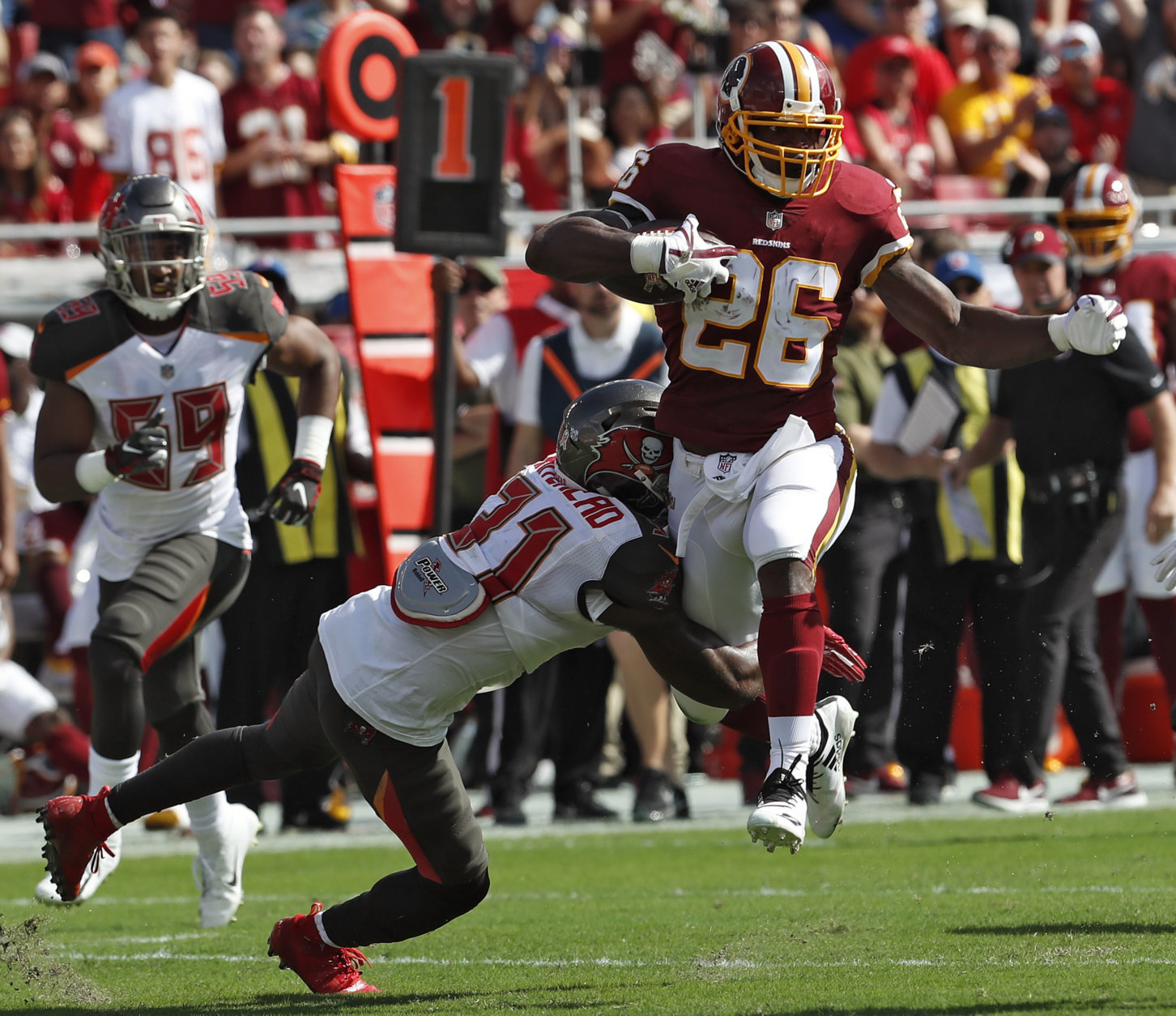 Washington Redskins running back Adrian Peterson (26) eludes a tackle by Tampa Bay Buccaneers free safety Jordan Whitehead (31) during the first half of an NFL football game Sunday, Nov. 11, 2018, in Tampa, Fla. (AP Photo/Mark LoMoglio)