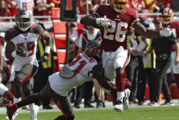 Washington Redskins running back Adrian Peterson (26) eludes a tackle by Tampa Bay Buccaneers free safety Jordan Whitehead (31) during the first half of an NFL football game Sunday, Nov. 11, 2018, in Tampa, Fla. (AP Photo/Mark LoMoglio)