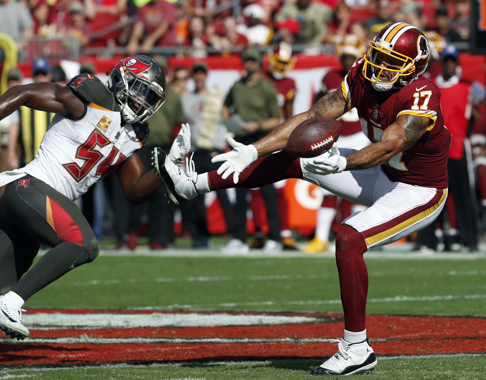 Washington Redskins wide receiver Michael Floyd (17) reaches for the ball after getting around Tampa Bay Buccaneers outside linebacker Lavonte David (54) during the first half of an NFL football game Sunday, Nov. 11, 2018, in Tampa, Fla. (AP Photo/Mark LoMoglio)