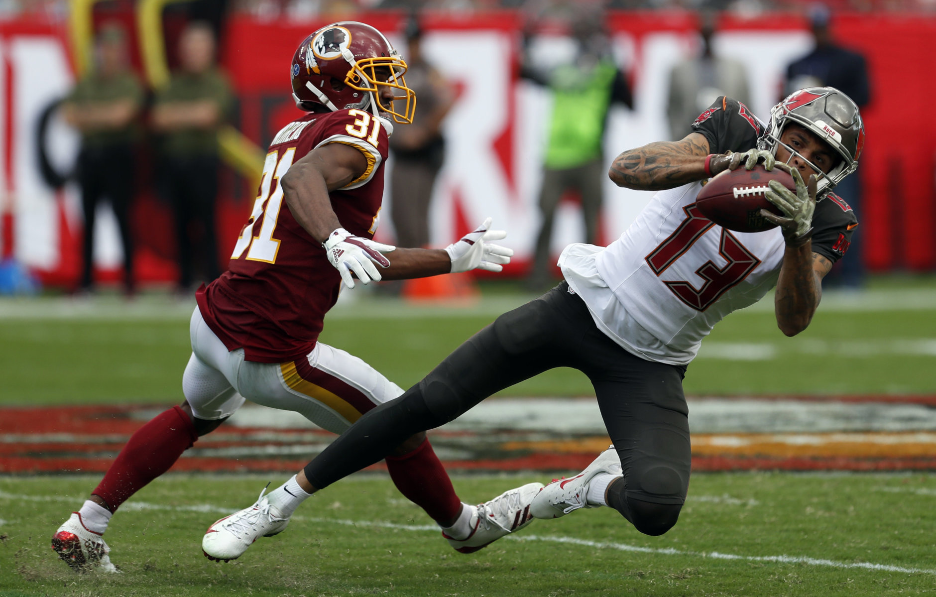 Tampa Bay Buccaneers wide receiver Mike Evans (13) makes a reception in front of Washington Redskins cornerback Fabian Moreau (31) during the second half of an NFL football game Sunday, Nov. 11, 2018, in Tampa, Fla. (AP Photo/Mark LoMoglio)