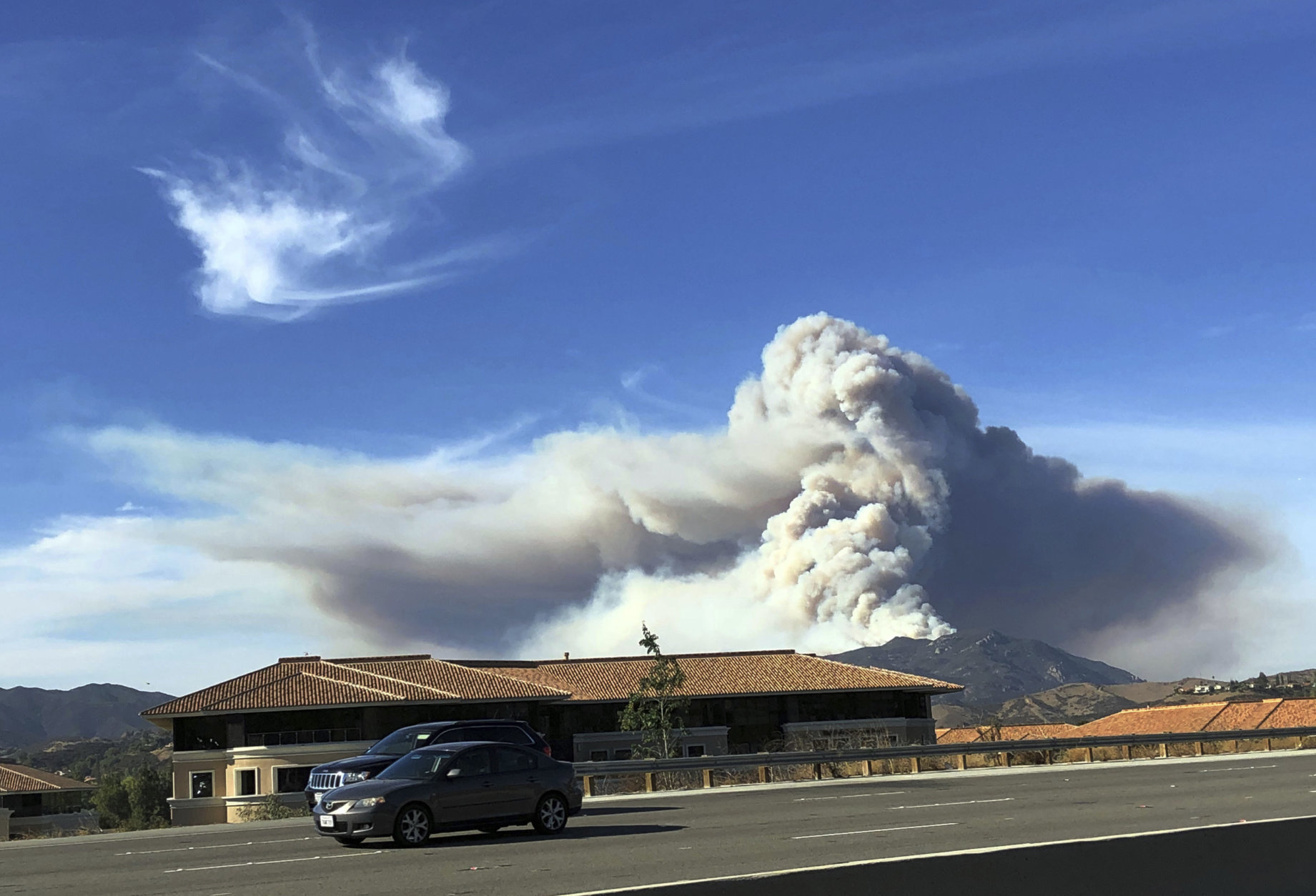 A large wildfire plume from a recent flareup near Lake Sherwood, Calif., is visible from Highway 101 north of Los Angeles, Tuesday, Nov. 13, 2018. (AP Photo/Amanda Myers)