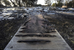 A burned wooden walkway leads to a home destroyed by the Woolsey Fire on Dume Drive in the Point Dume area of Malibu in Southern California, Tuesday, Nov. 13, 2018. (AP Photo/Reed Saxon)