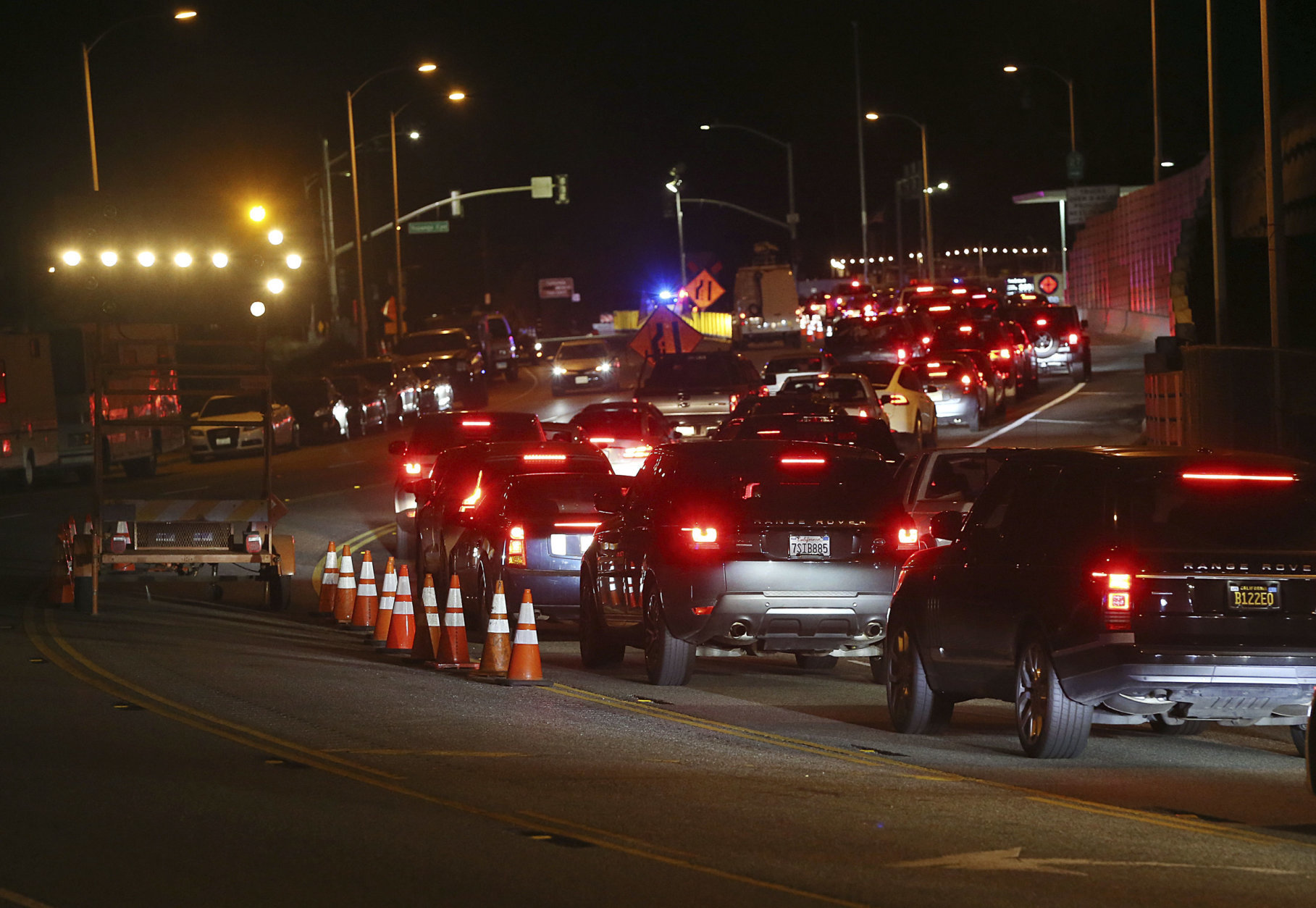 A long line of residents seeking to return to Malibu, Calif., in Southern California wait at a checkpoint on Pacific Coast Highway after Woolsey Fire evacuation orders were lifted for the eastern portion of the city Tuesday evening, Nov. 13, 2018. (AP Photo/Reed Saxon)
