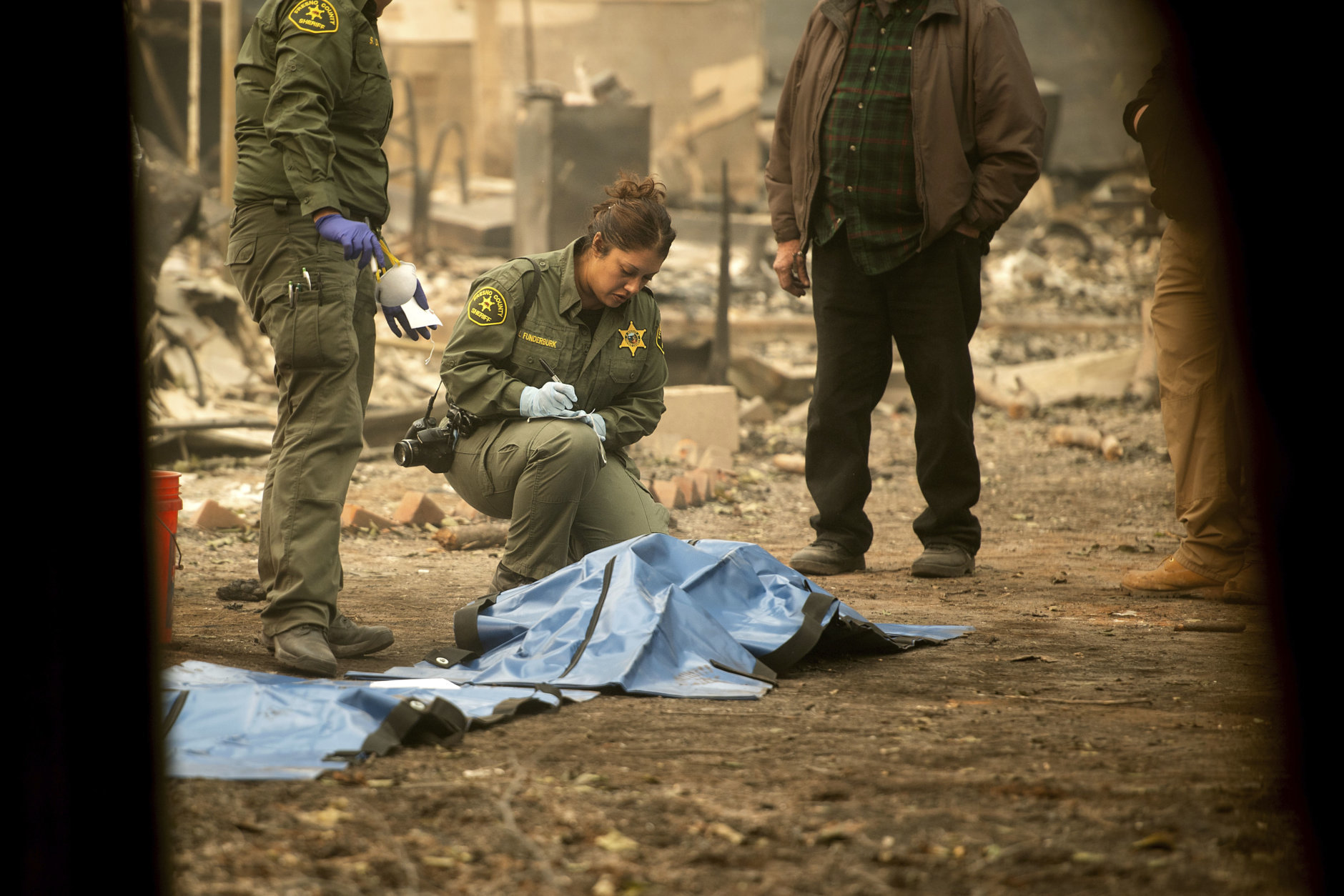 Sheriff's deputies recover the bodies of multiple Camp Fire victims from a Holly Hills Mobile Estates residence on Wednesday, Nov. 14, 2018, in Paradise, Calif. (AP Photo/Noah Berger)