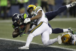 Seattle Seahawks tight end Ed Dickson, left, dives past Green Bay Packers defensive back Ibraheim Campbell, center, to score a touchdown after a reception during the second half of an NFL football game, Thursday, Nov. 15, 2018, in Seattle. (AP Photo/Stephen Brashear)