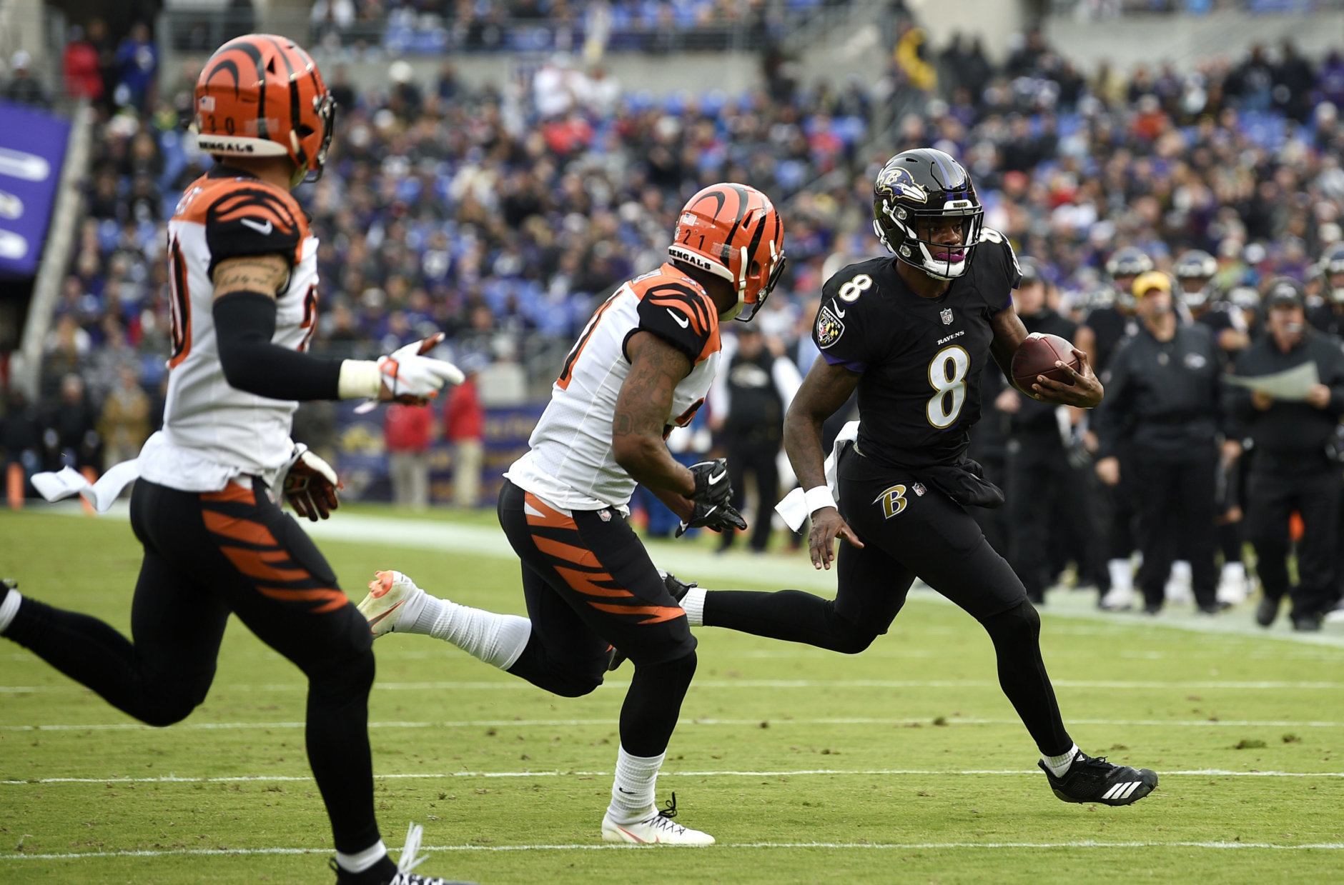 Baltimore Ravens quarterback Lamar Jackson (8) rushes the ball against Cincinnati Bengals defensive back Darqueze Dennard, center, and free safety Jessie Bates in the first half of an NFL football game, Sunday, Nov. 18, 2018, in Baltimore. (AP Photo/Nick Wass)