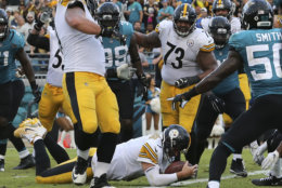 Pittsburgh Steelers quarterback Ben Roethlisberger dives over the goal line for the go ahead touchdown in front of Jacksonville Jaguars outside linebacker Telvin Smith, right, during the final seconds of an NFL football game, Sunday, Nov. 18, 2018, in Jacksonville, Fla. (AP Photo/Gary McCullough)
