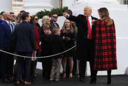 President Donald Trump and first lady Melania Trump wave to invited guests during a ceremony to receive the White House Christmas Tree, presented by tree grower Larry Smith and the Smith family at the North Portico of the White House, in Washington, Monday, Nov. 19, 2018. The North Carolina-grown 19 1/2-foot-tall Fraser Fir will be displayed in the Blue Room of the White House. (AP Photo/Manuel Balce Ceneta)
