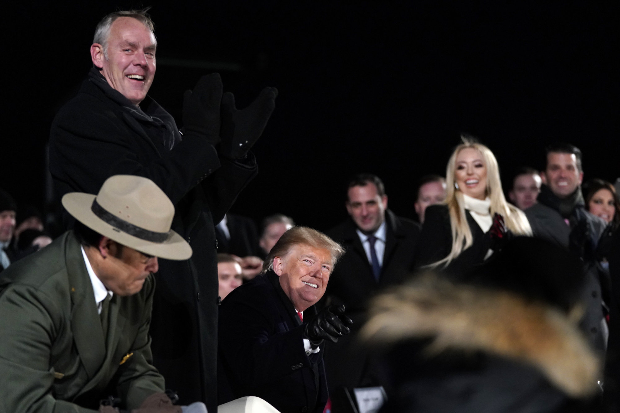 Interior Secretary Ryan Zinke, left, stands as President Donald Trump watches during the National Christmas Tree lighting ceremony on the Ellipse near the White House in Washington, Wednesday, Nov. 28, 2018. (AP Photo/Andrew Harnik)