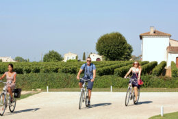 This Sept. 5, 2013 photo provided by Charmaine Noronha shows Noronha (left) and two other passengers from Crystal Serenity on a bike tour during a port call in St.-Emilion in the wine region of France. Excursions like bike tours are popular among cruisers who enjoy active adventures in port, and there are a variety of similar adventures to choose from. (AP Photo/Charmaine Noronha)