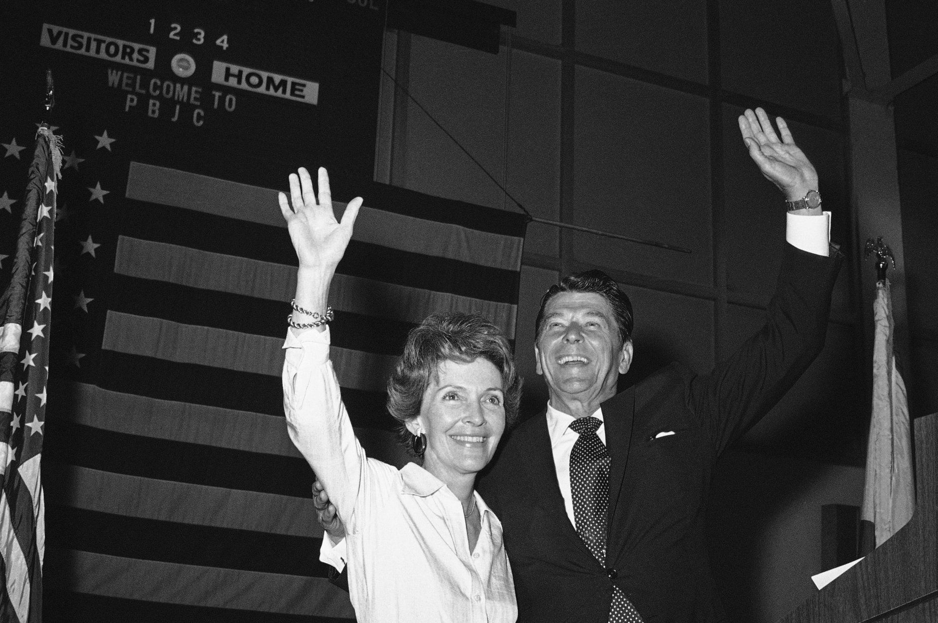 Former California Governor Ronald Reagan, Republican candidate for President, and his wife Nancy, raise their arms in response to loud applause as they stand on the podium, March 8, 1976 in Lake Worth, Fla. The rally for Reagan, was held at the Palm Beach Junior College. (AP Photo/Robert H. Houston)