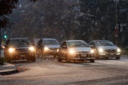 Cars wait at a traffic light in Northwest D.C. as snow falls. (WTOP/Dave Dildine)