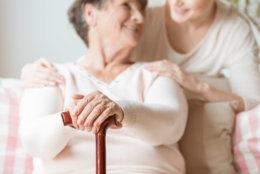 Close-up of elderly woman holding walking stick in the nursing house