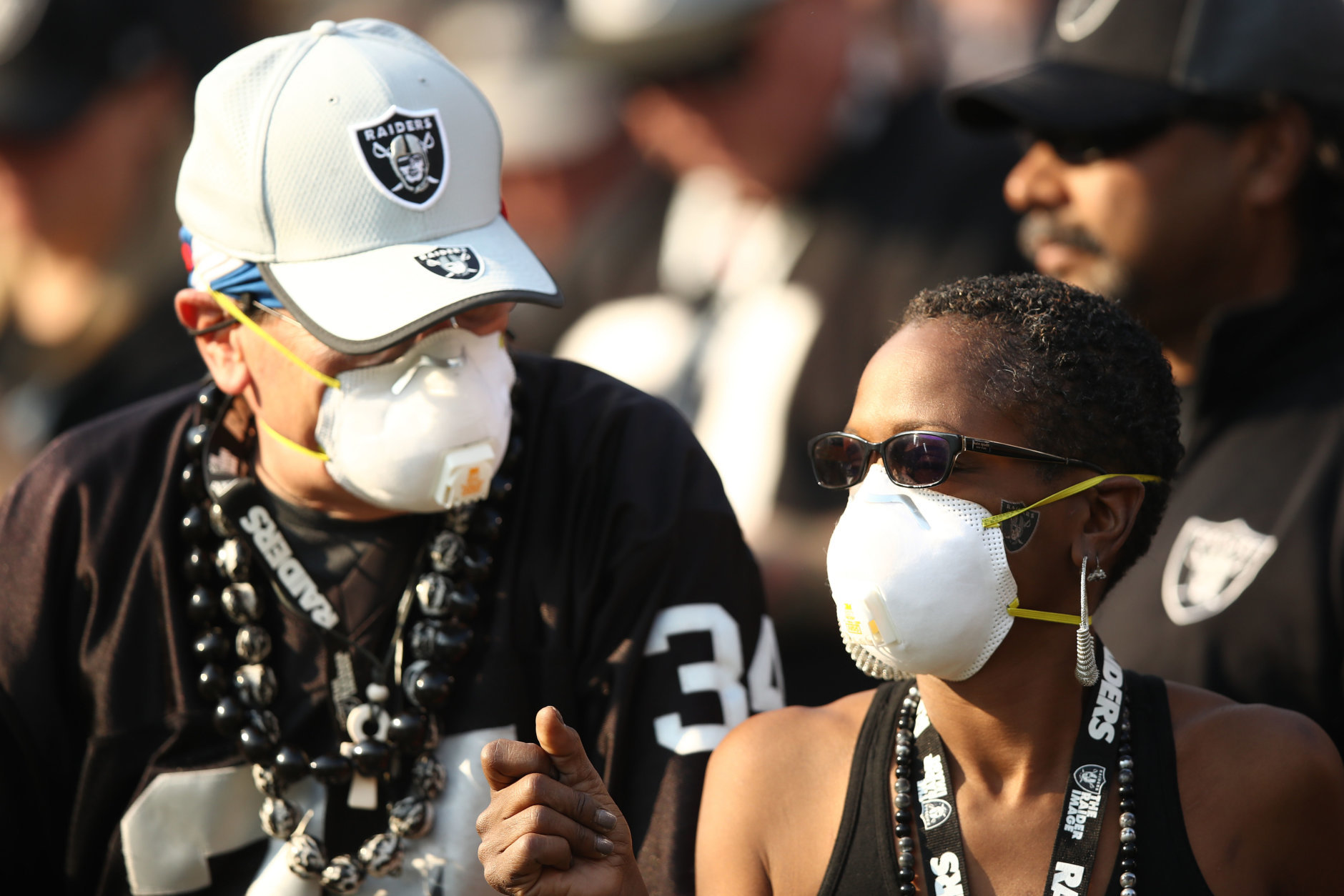 OAKLAND, CA - NOVEMBER 11: Fans wear face masks in the stands during the NFL game between the Oakland Raiders and the Los Angeles Chargers at Oakland-Alameda County Coliseum on November 11, 2018 in Oakland, California. An Air Quality Advisory was issued due to heavy wildfire smoke in parts of the Bay Area from the Camp Fire in Butte County. (Photo by Ezra Shaw/Getty Images)