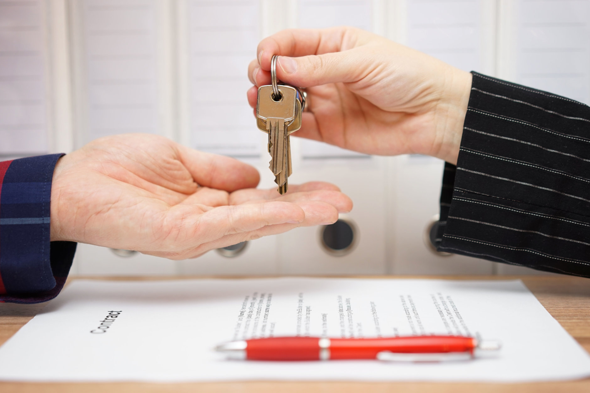 real estate seller is giving keys to buyer after signed deal