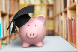 Piggy Bank with Graduation Hat on light background