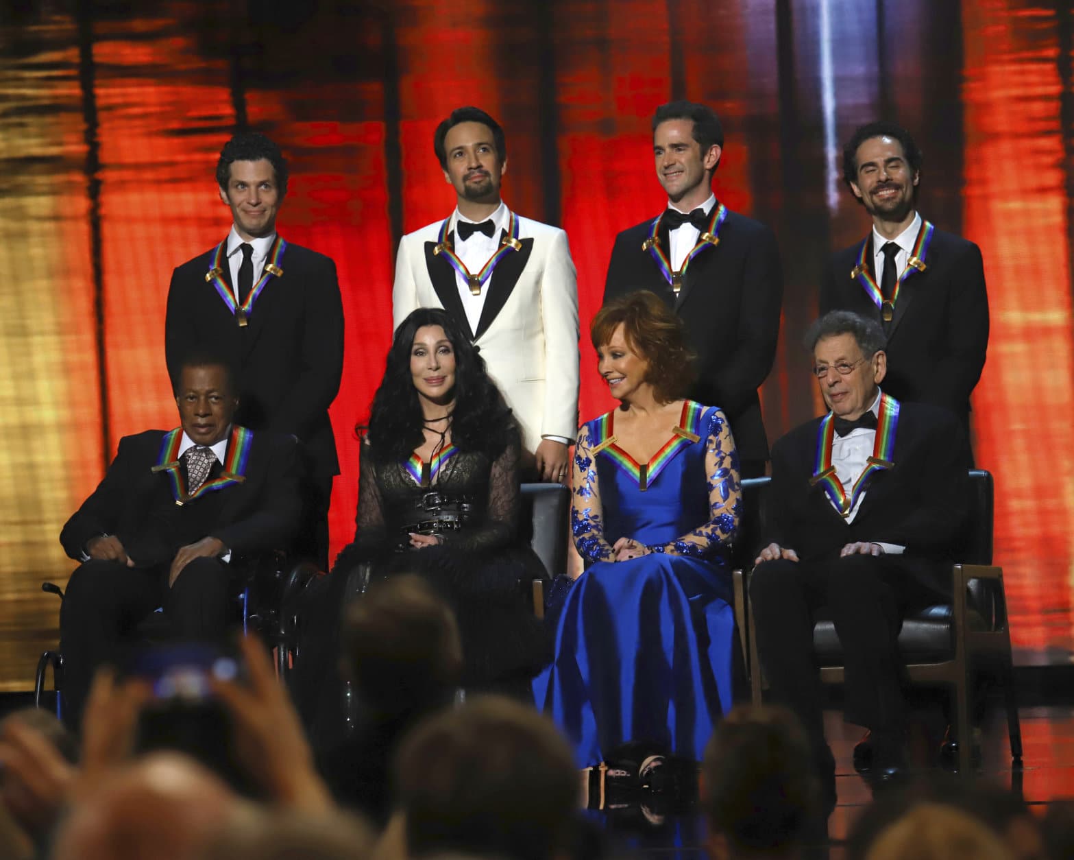 2018 Kennedy Center honorees, front row from left, Wayne Shorter, Cher, Reba McEntire and Philip Glass; and back row from left, the co-creators of "Hamilton," Thomas Kail, Lin-Manuel Miranda, Andy Blankenbuehler and Alex Lacamoire appear on stage during the 41st Annual Kennedy Center Honors at The Kennedy Center, Sunday, Dec. 2, 2018, in Washington. (Photo by Greg Allen/Invision/AP)