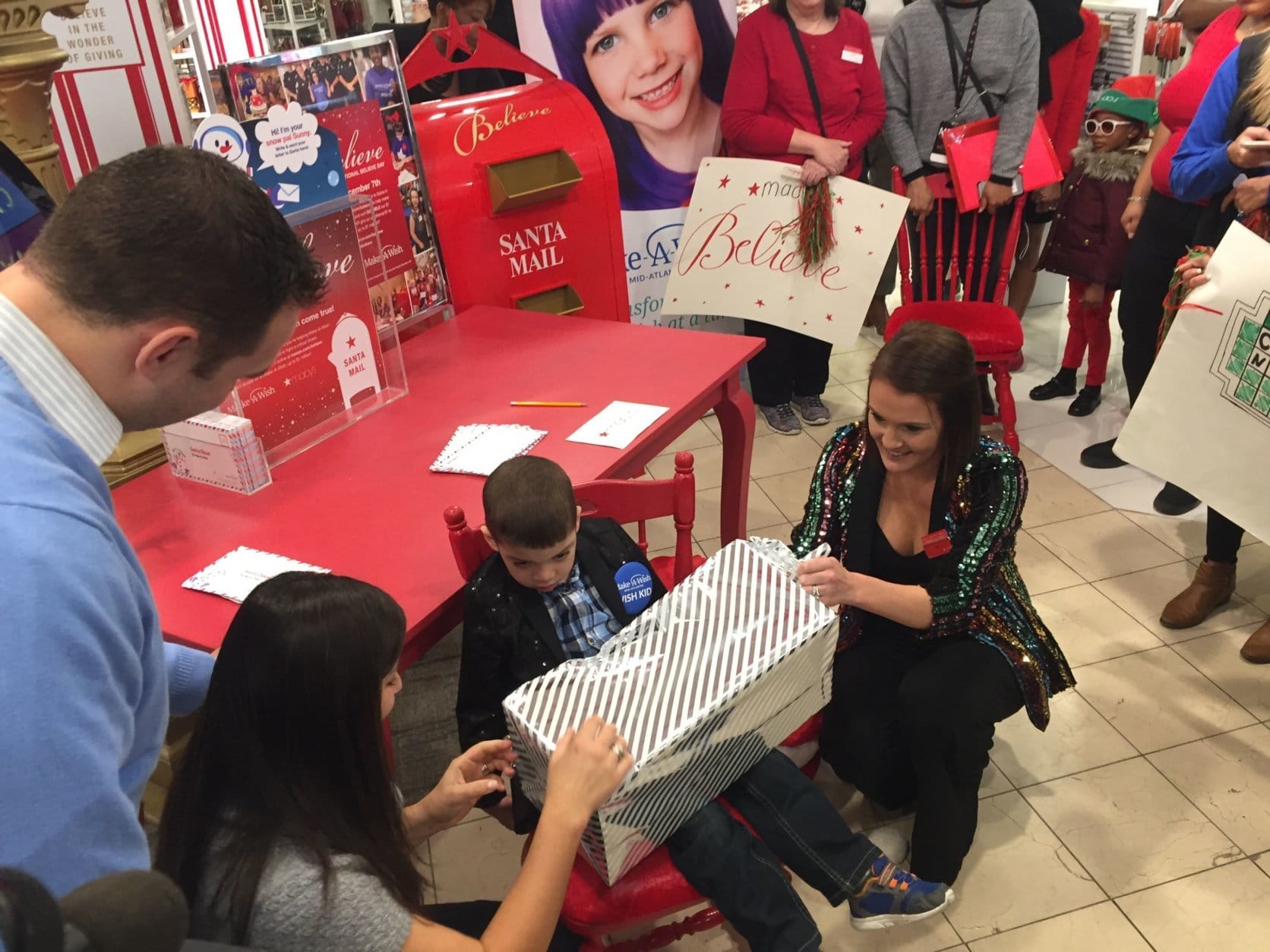 Nikolas got to spin his own wheel that led to Jenna Wallach, a manager at Macy’s, to reach into her bag and pull out a big toy truck all wrapped up. (WTOP/John Domen)