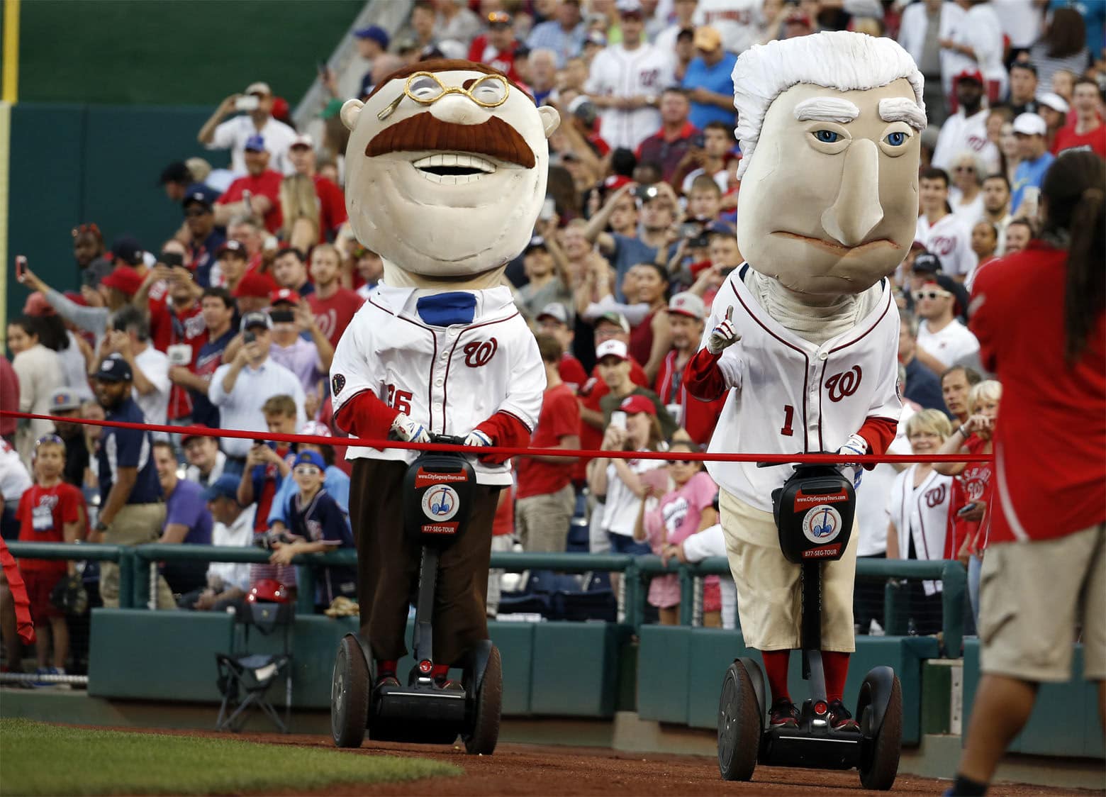 Washington Nationals Racing Presidents, President Teddy Roosevelt and President George Washington use Segways during their race during a baseball game against the Chicago Cubs at Nationals Park, Monday, June 13, 2016, in Washington. (AP Photo/Alex Brandon)