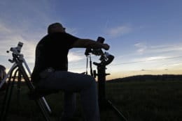 Mark Renz, of Rochester, N.Y, adjusts one of his telescopes during the period of total coverage during the solar eclipse Monday, Aug. 21, 2017, on the Orchard Dale historical farm near Hopkinsville, Ky. The location, which is in the path of totality, is also at the point of greatest intensity. (AP Photo/Mark Humphrey)